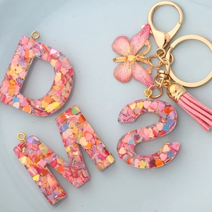 Resin alphabet keychain D M S with heart sequins, gold butterfly charm and pink tassel