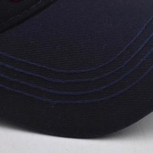 Vista macro de las costuras en la visera de la gorra de béisbol de algodón azul marino