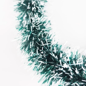 Close-up of green and white Christmas tinsel garland with shiny reflective metallic texture