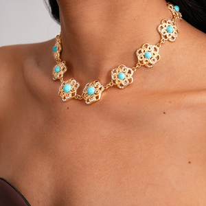 Close-up of vintage hollow flower necklace with turquoise stone and sparkling rhinestones
