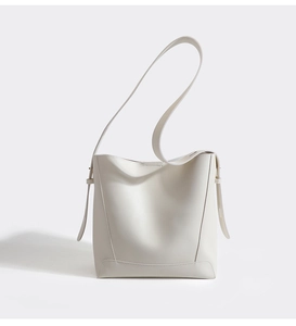 Detail shot of the white bucket bag featuring smooth leather texture and adjustable strap