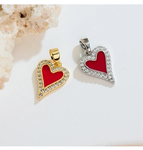 Detailed close-up of heart pendants with red enamel and pavé zircon stones