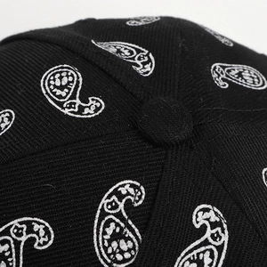 Macro detail of black paisley baseball cap showing high-density twill fabric and stitching