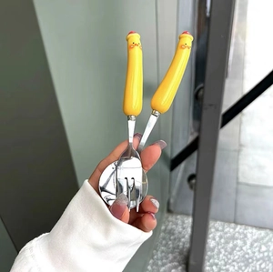 Detail of cute yellow chick handles on stainless steel fork and spoon set