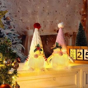 Lighted Christmas gnomes with knitted hats and LED warm lights on mantelpiece