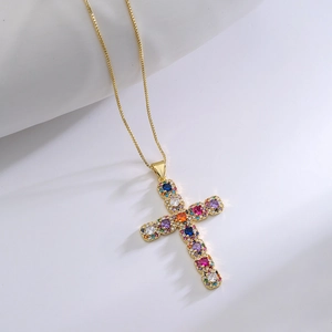 Macro detail of gold-plated cross pendant featuring vibrant colorful zircon gemstones