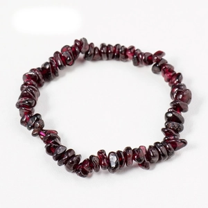 Macro detail of handmade natural garnet irregular stone bracelet with deep red crystal texture