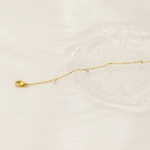 Detail of gold chain bracelet with heart zircon stones and secure lobster clasp closure