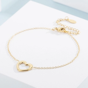Detailed view of a gold hollow heart bracelet with lobster clasp and extension chain