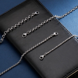 Silver stainless steel pearl chain bracelets in various sizes on black leather surface