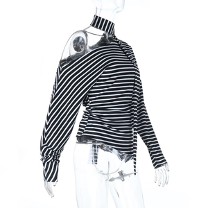 Détail du tissu en maille rayé noir et blanc sur un haut à manches longues et épaule nue