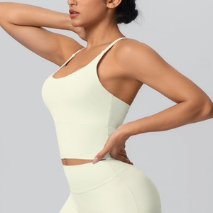 Détail du soutien-gorge de sport jaune à dos croisé et du legging de yoga à taille haute