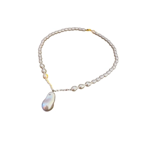 Baroque pearl necklace with large teardrop pendant and golden bead accents on white background