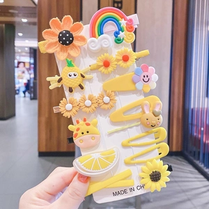 Detail of yellow cartoon hair clips for girls featuring sunflower and rainbow designs