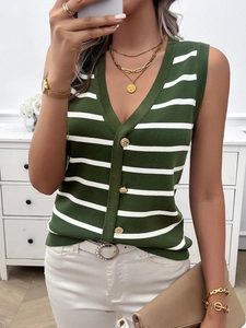 Dettaglio di un gilet in maglia verde con scollo a V, strisce e bottoni dorati decorativi