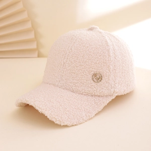 Beige lamb wool baseball cap with golden M logo badge on a textured warm fabric