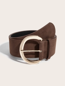 Détail d'une ceinture large marron mate avec une boucle ronde en métal doré proéminente