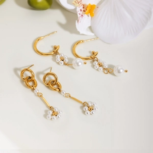 Dettaglio degli orecchini a cerchio in acciaio placcato oro 18K con fiori di perla
