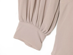 Detalle de los puños elegantes y las finas costuras plisadas en el vestido de gasa malva