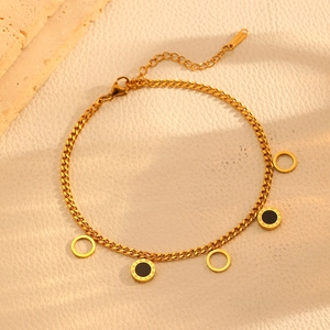 Detail of 316L stainless steel gold bracelet with Roman numeral and open ring charms