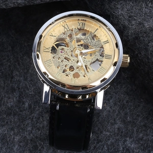Macro detail of men's mechanical watch with golden skeleton dial and black leather strap