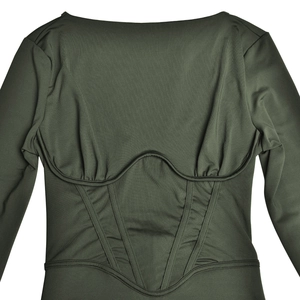 Détails de la robe verte à manches longues avec corsage cintré et coutures structurées