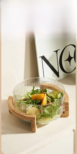 Detailed view of large vertical stripe glass salad bowl with elegant wooden stand