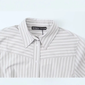 Gros plan du col de chemise à rayures gris et blanc avec étiquette de marque MYST&ZA et taille