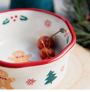 Close-up of a Christmas gingerbread man ceramic bowl with red rim and festive patterns