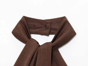 Detail of dark brown fabric halter neck knot and stitching on the top garment