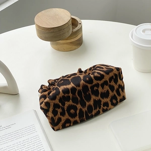 Leopard print makeup bag on a minimalist white table with chic aesthetic lifestyle decor