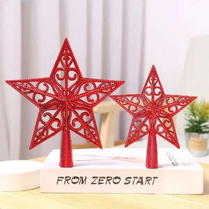 Set of two red metal wire hollow star Christmas tree toppers on a vintage book