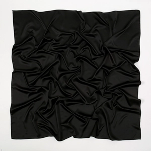Detail showing the smooth matte texture and elegant folds of the black satin silk square scarf