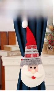 Détail d'un embrasse de rideau Père Noël sur rideau bleu dans un décor festif et chaleureux