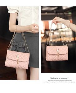 Close-up of pink quilted crossbody bag with pearl cat ear clasp and golden chain strap