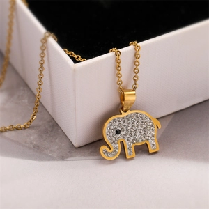 Close-up of a gold elephant pendant necklace encrusted with sparkling rhinestones on marble
