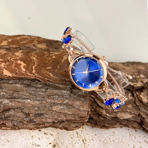 Elegant rose gold bracelet watch featuring a blue dial and sparkling gemstone accents