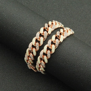 Close-up of rose gold Cuban link bracelet with white enamel and sparkling rhinestones
