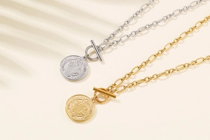 Detail of gold and silver St. Benedict coin pendants with T-bar toggle on O-link chains