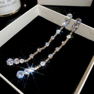 Macro shot of long tassel earrings with sparkling teardrop zircons in a jewelry gift box