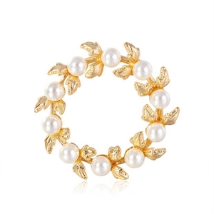 Detailed view of the gold leaf brooch featuring elegant circular pearl wreath design