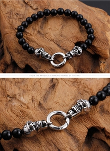 Macro detail of punk skull bracelet with black beads and silver metal skull clasp