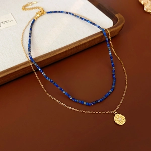 Détail d'un collier double épaisseur avec perles bleues et pendentif étoile doré