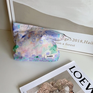 Detail of floral canvas makeup bag with vintage oil painting pattern and woven logo