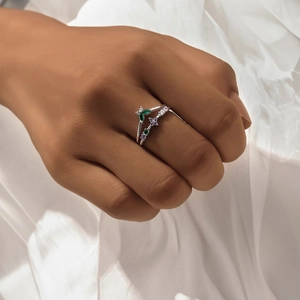 Detail of stacked S925 silver rings with green marquise and purple floral zircons