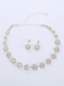Detail shot of silver necklace and earrings set with shimmering round crystals