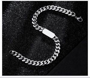 Macro shot of a silver titanium steel Cuban link bracelet with a smooth polished ID plate