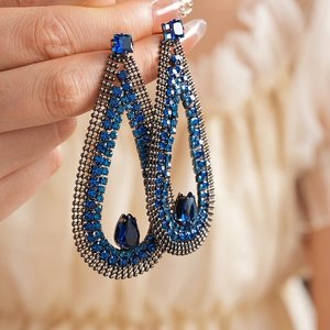 Detailed view of hollow teardrop earrings with dark blue zircons and black metal mesh
