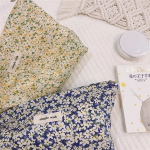 Detail of floral cotton makeup bags in yellow and blue with a simple wish woven label