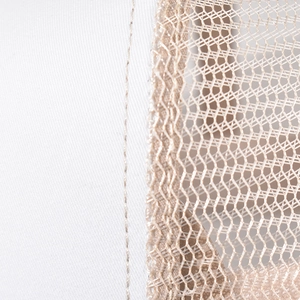 Close-up of white cotton fabric and khaki mesh texture with detailed stitching on the cap